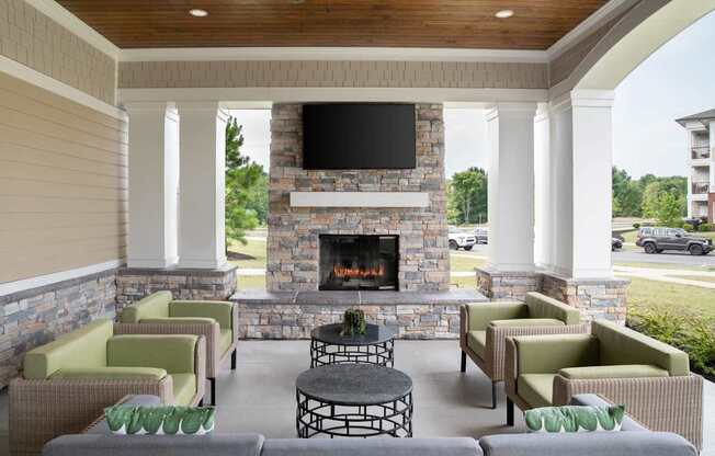 A patio with a fireplace and chairs.