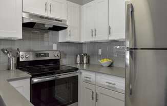 a kitchen with stainless steel appliances and white cabinets