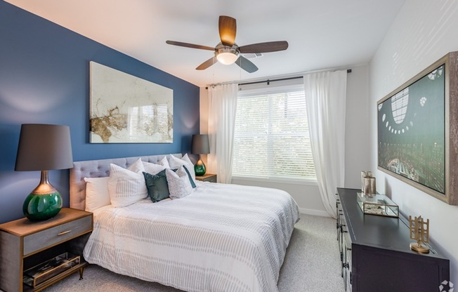 bedroom with ceiling fan and large window