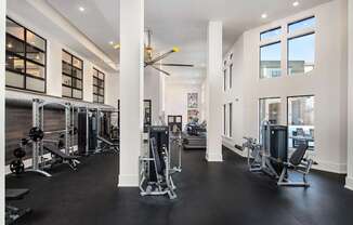 A gym with a variety of equipment and a large mirror on the wall.