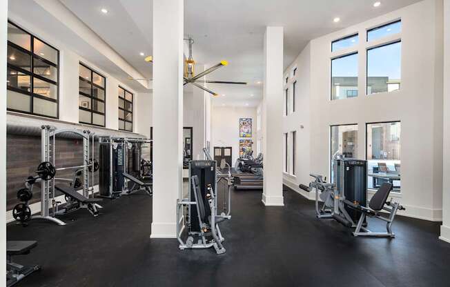 A gym with a variety of equipment and a large mirror on the wall.