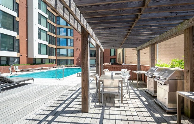 a patio with tables and chairs and a swimming pool