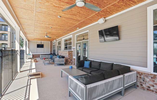 a covered porch with a couch and a coffee table