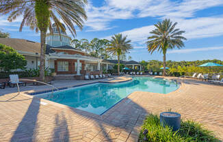 a swimming pool with palm trees in front of a house