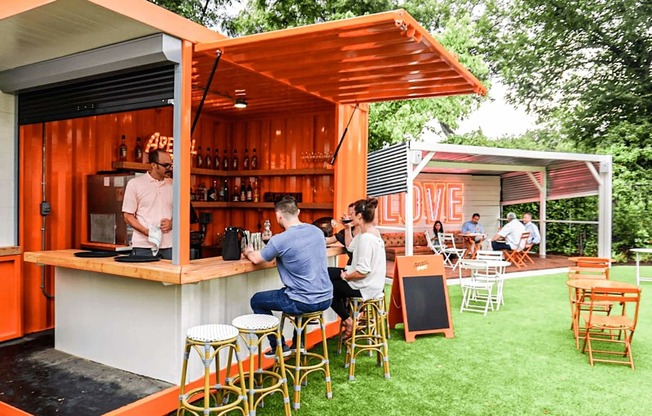 a bar with people sitting at it on the grass