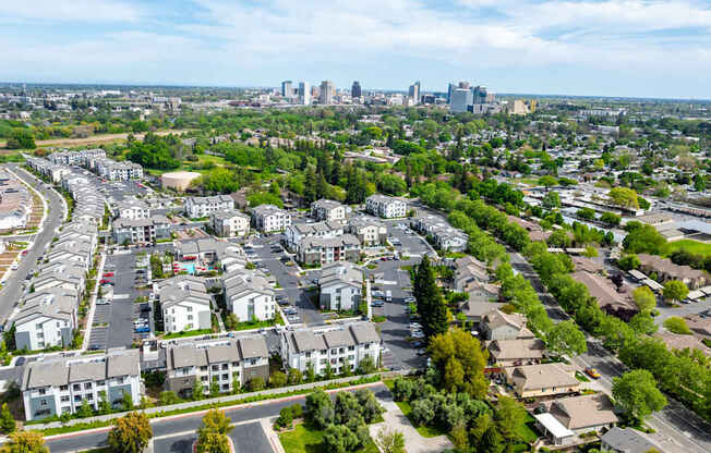A suburban area with apartment buildings and a city skyline in the distance.