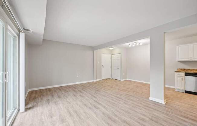 the living room and kitchen of an empty house with wood flooring at ReNew Odenton