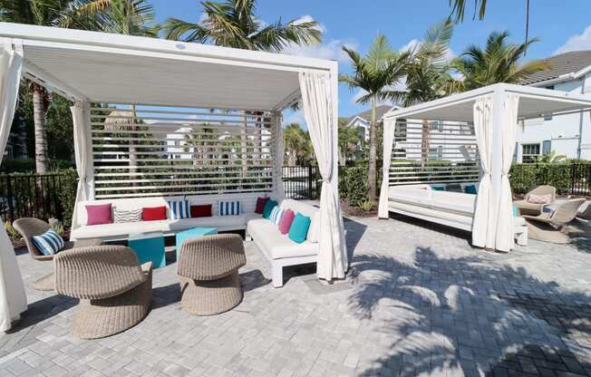 a covered patio with chairs and a hammock