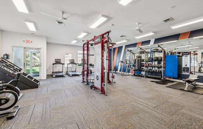 A gym with a variety of equipment including a weight rack, treadmill, and exercise bench.