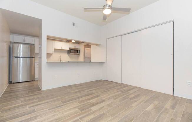 A kitchen area with a refrigerator, microwave, and cabinets.