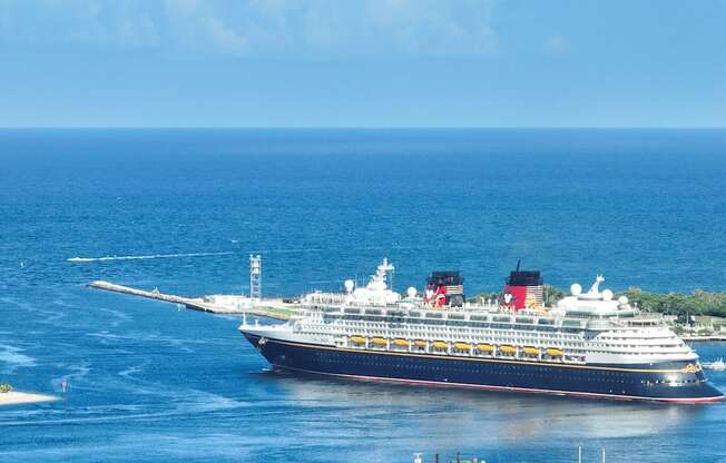 a cruise ship in the ocean near a beach