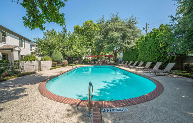 a swimming pool in a yard with trees and a house