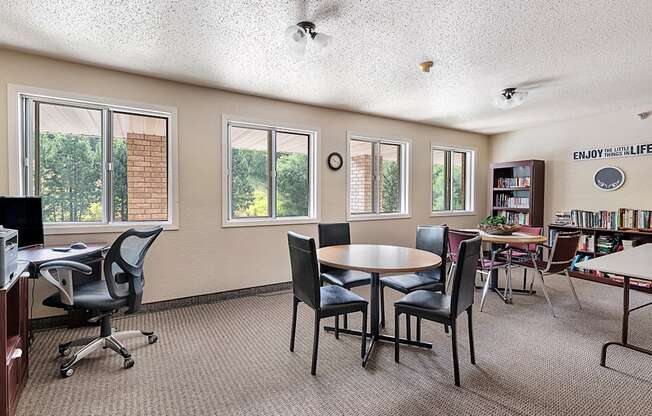 a classroom with tables and chairs and a library