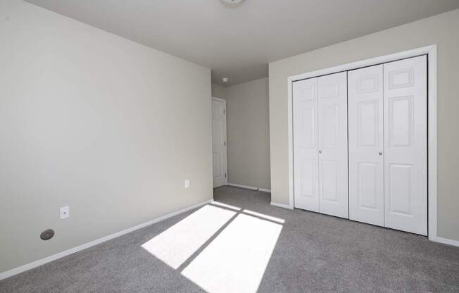 A room with a white ceiling, two white doors, and a carpeted floor.