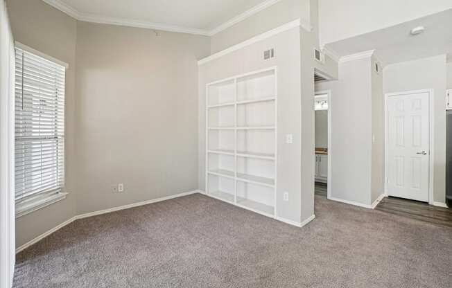 A room with a white door and a window with blinds.