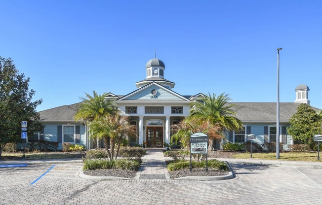 the front of a building with palm trees in front of it