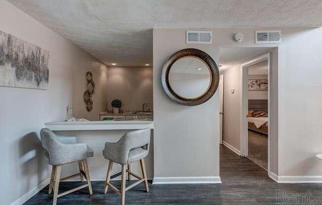 a kitchen with stools and a counter with a mirror