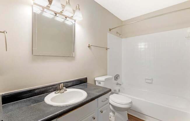 A bathroom with a sink, toilet, and bathtub.