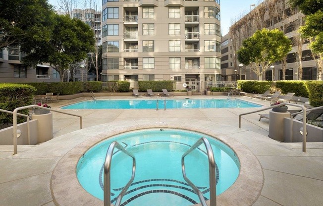 A small pool in a courtyard surrounded by buildings.