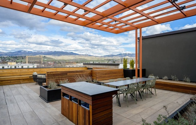 a terrace with a table and chairs under a roof at The Lucy Boise Apartments, Idaho, 83702