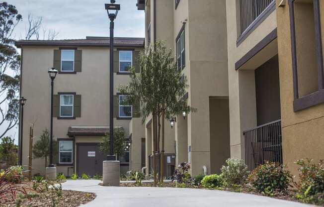 an empty sidewalk in front of an apartment building