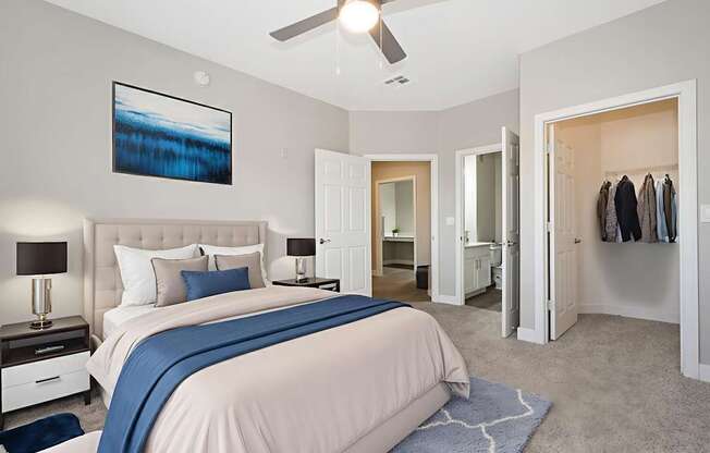 A bedroom with a large bed and a ceiling fan.
