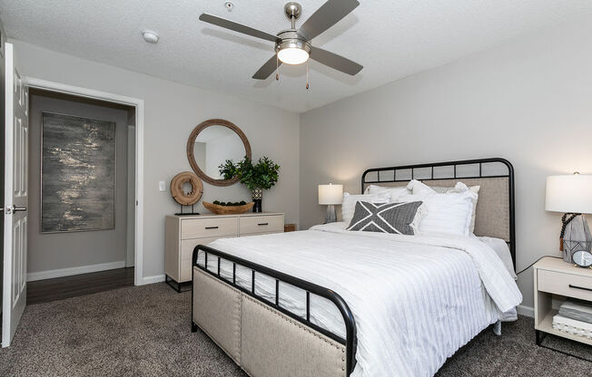 a bedroom with a bed and a ceiling fan