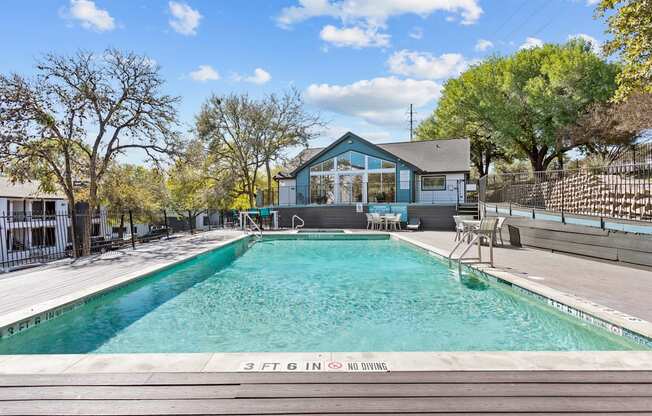 a swimming pool with a house in the background