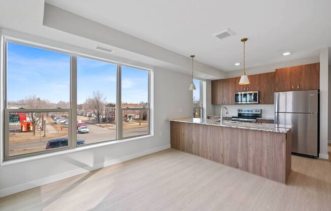 A kitchen with a refrigerator, sink, and stove is shown in the image.
