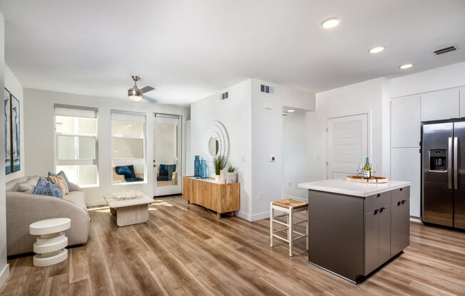 A modern kitchen with a refrigerator, stove, and island.
