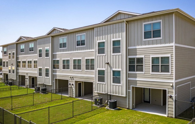 an image of an apartment building with a grassy yard