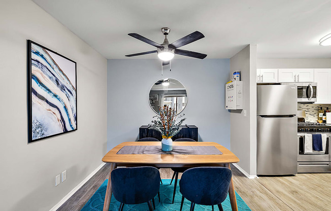 A dining room with a wooden table and blue chairs.