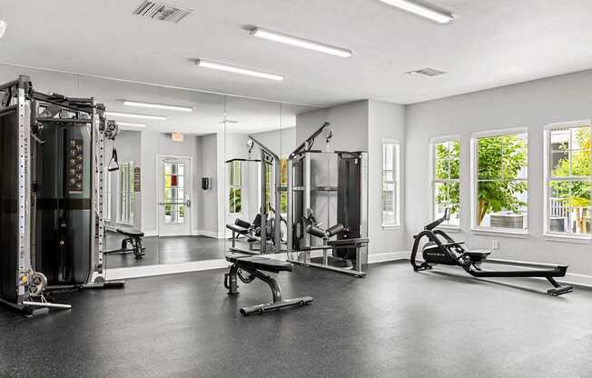 A spacious gym with a variety of equipment including a treadmill, a bench press, and a squat rack.