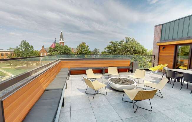 a rooftop terrace with chairs and tables and a fire pit at Canary Lofts, Des Moines, 50311