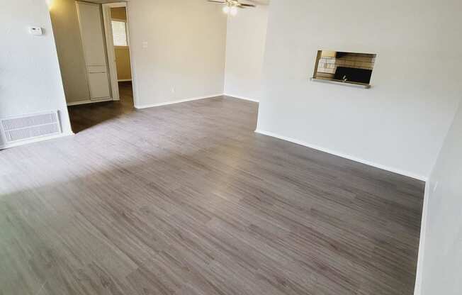 an empty living room and dining room with wood flooring