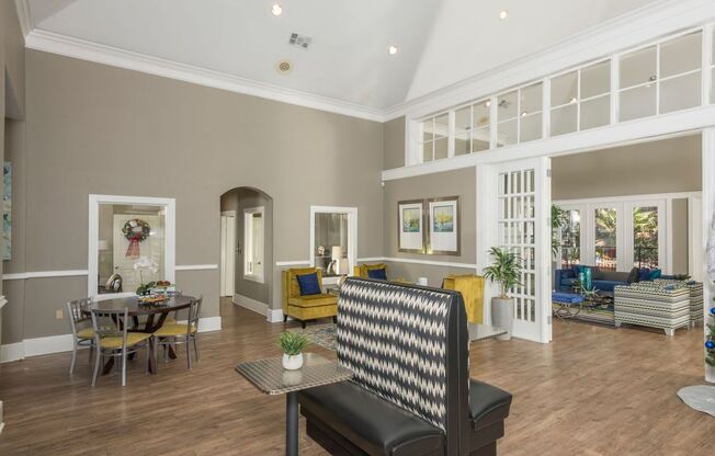 a living room with a couch and a chair in front of a table with a plant on