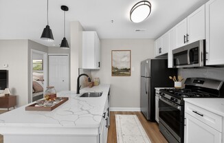 Welcome to Eagle Rock Apartments at Columbia Pike, where modern living meets convenience. This stylish kitchen features sleek appliances and beautiful finishes, perfect for culinary adventures. Explore your new home today!