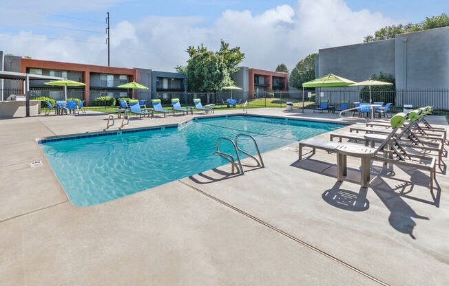 Community Swimming Pool with Pool Furniture at Indigo Park Apartments in Albuquerque, NM.