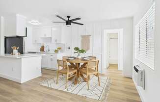 A modern kitchen with a dining table set for two.