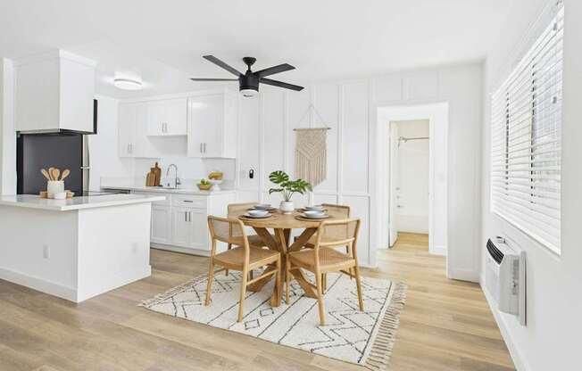 A modern kitchen with a dining table set for two.