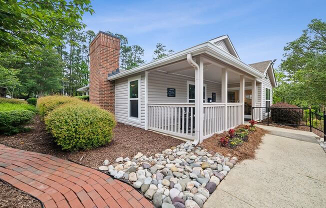 the front porch of a white house with a walkway and rocks at Chapel View Apartments in Chapel Hill, NC