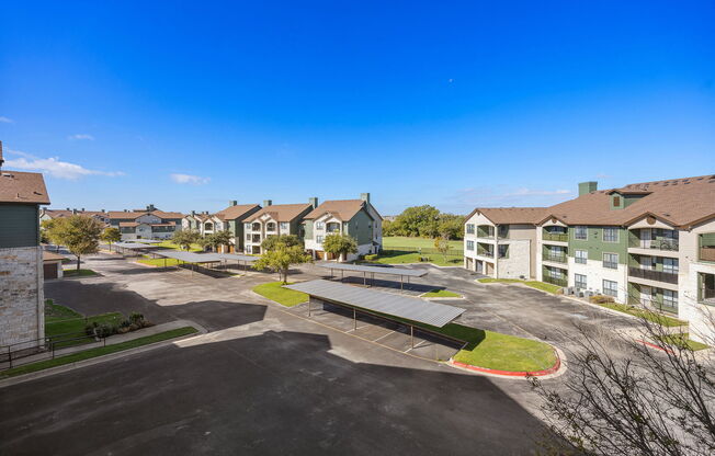 an aerial view of an empty parking lot with houses in the background at The Fairways at Star Ranch, Hutto, TX, 78634