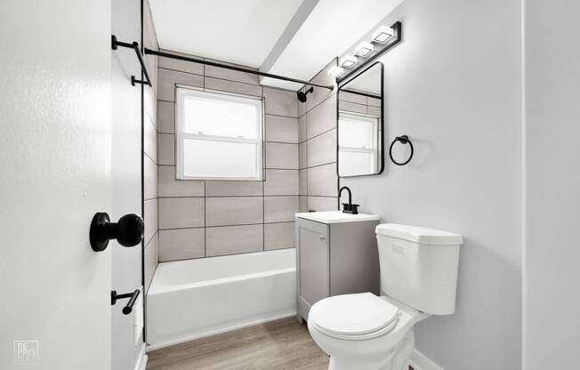 a bathroom with gray walls and white fixtures