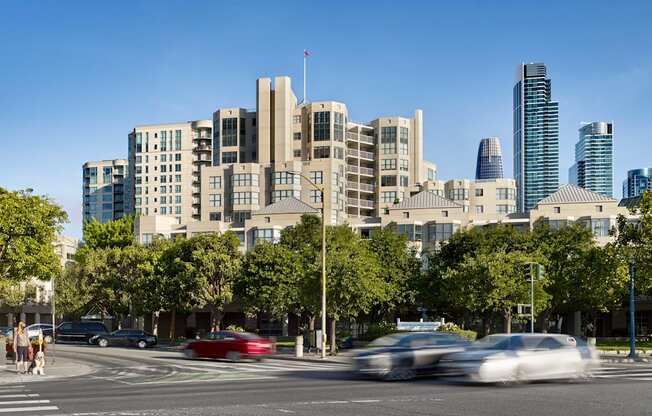 A city street with cars and buildings in the background.