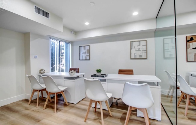 a white office with a white desk and chairs