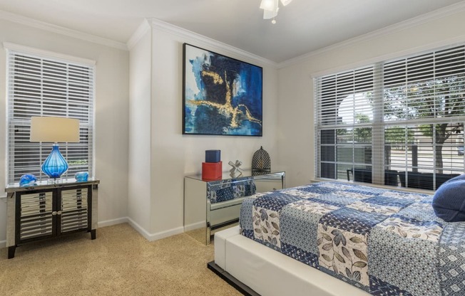 staged bedroom with carpeted flooring, ceiling fan, and windows