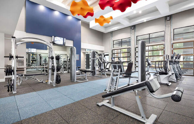 a gym with weights and cardio equipment at aria on the avenue apartments