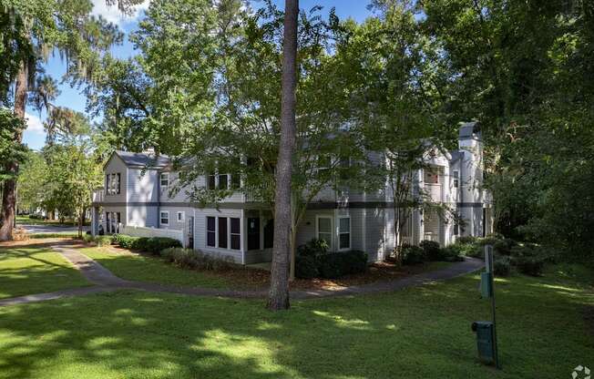 A large white house with a tree in front of it.
