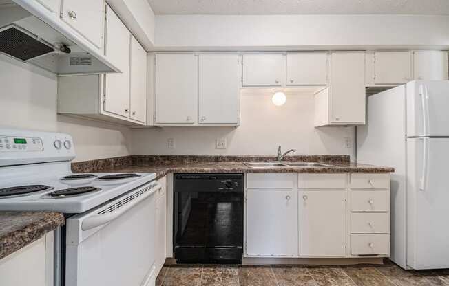Omaha, NE Evergreen Terrace Apartments. A kitchen with white cabinets and black appliances