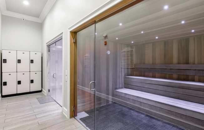 a large elevator lobby with a glass door and a bench in it at Crossgates Apartment Homes, Starkville, 39759